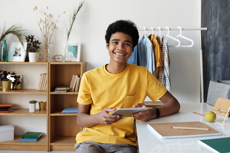 Teen in yellow shirt smiling at the camera
