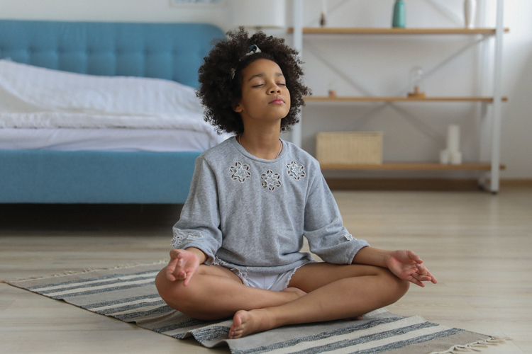 Child sitting on floor meditating