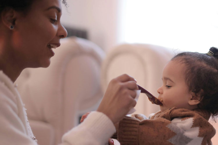 Parent feeding a young child