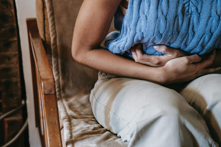 Person holding their stomach bent over